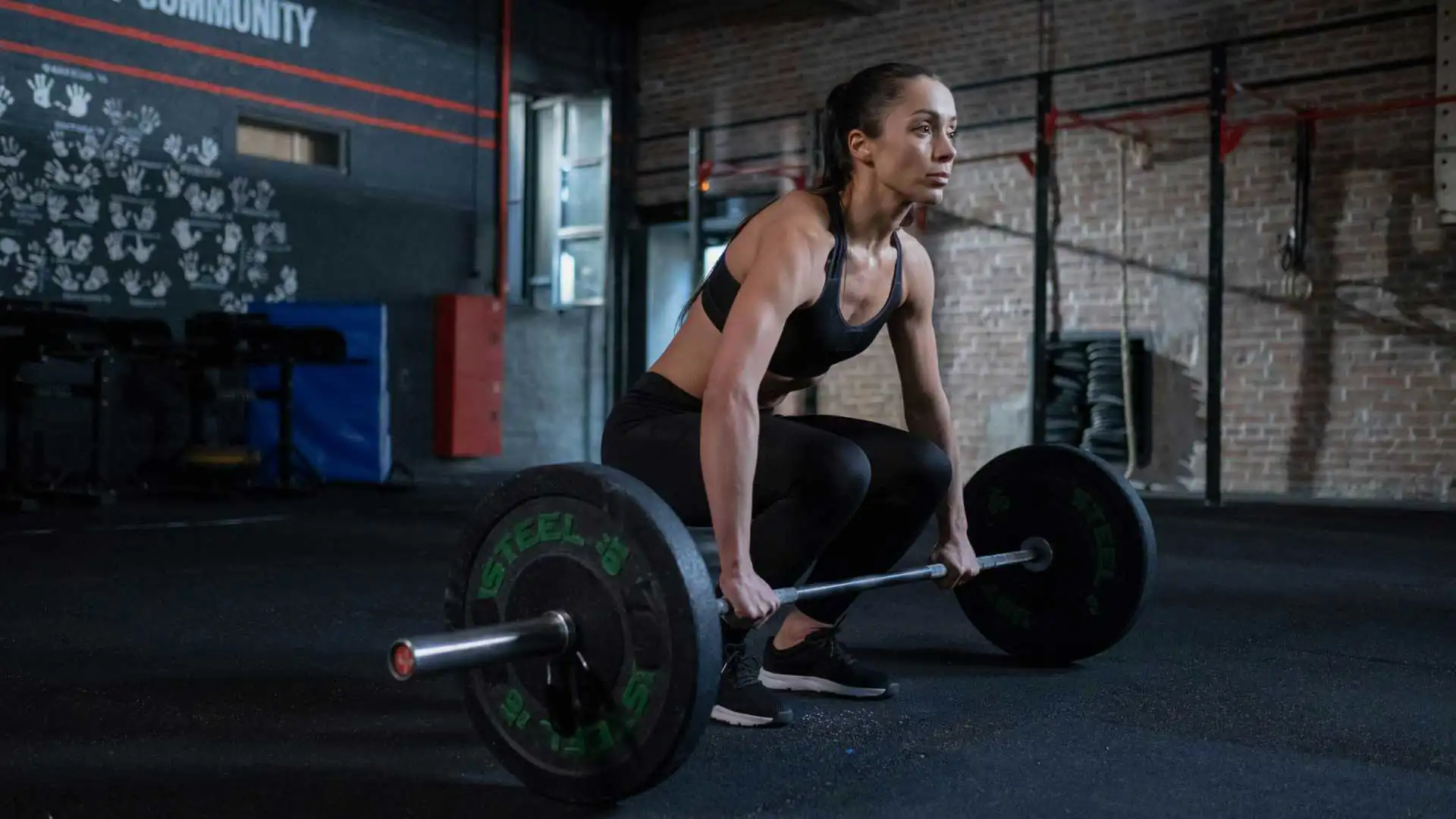 Una ragazza che solleva un bilanciere in una palestra
